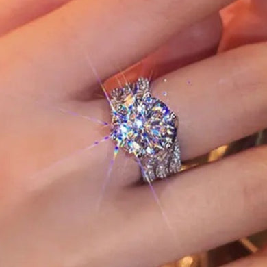 Close-up of a hand wearing a diamond ring with a blurred background